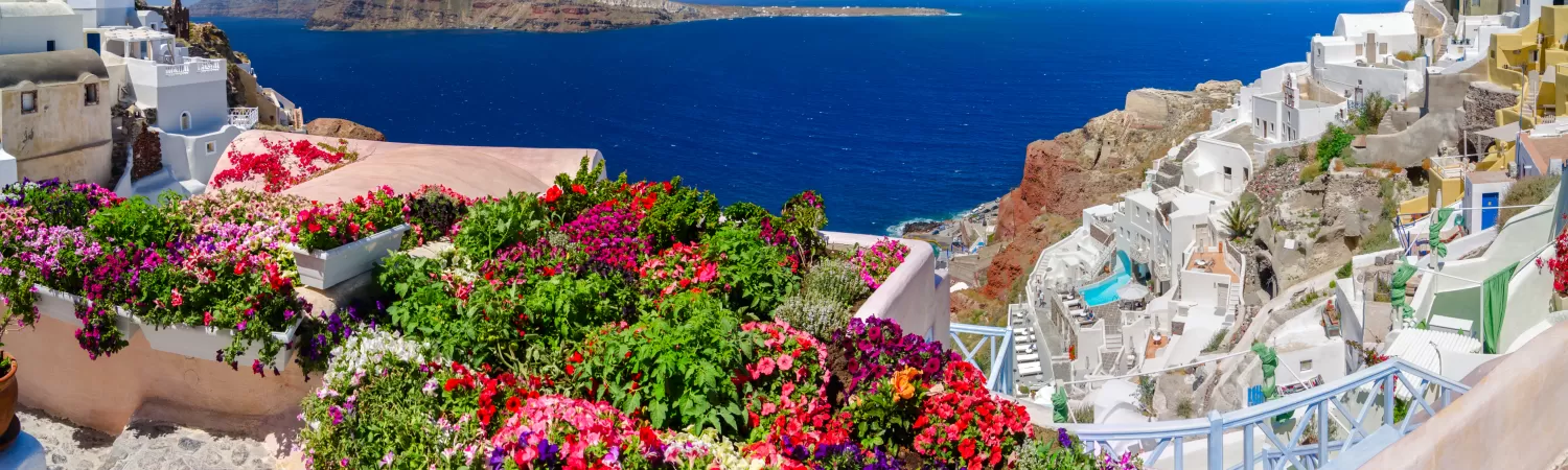 Colorful flowers and brilliant blue skies complement beautiful Greek islands