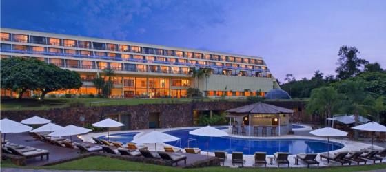 The exterior of the hotel by the pool at night.