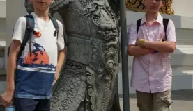 The boys next to a Bangkok statue