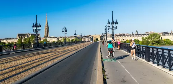 Cyclists crossing the Pont de Pierre, Bordeaux beside the Garonne River
