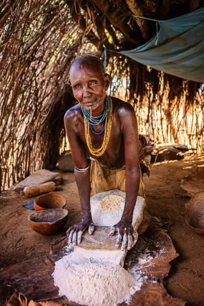 A woman grinding sorghum from the Karo tribe