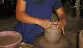making the pottery, a potters wheel spun by foot