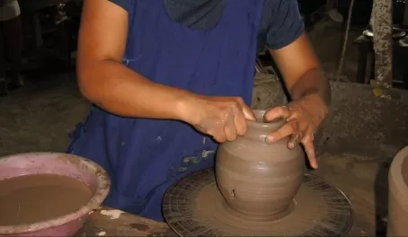 making the pottery, a potters wheel spun by foot