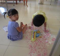 The children unwrapping their gifts - pencils, notebooks, coloring books, suckers and more