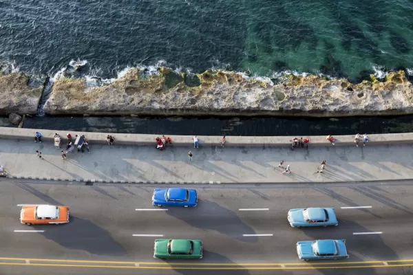 Vintage American cars speeding along the Malecon in Havana, Cuba