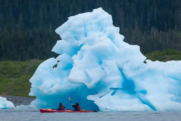 Kayak near icebergs calving from the glaciers