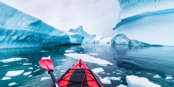 Kayaking glassy waters around incredible icebergs