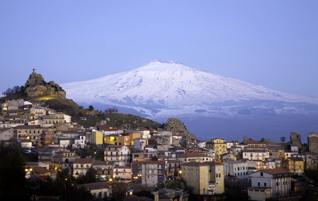 Blue hour over the city in the shadow of Mount Etna