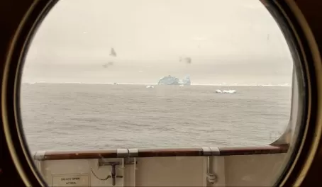 Out the porthole: first glimpse of an iceberg