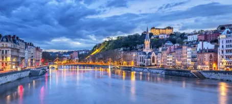 Warm lights glow through the blue hour in Lyon