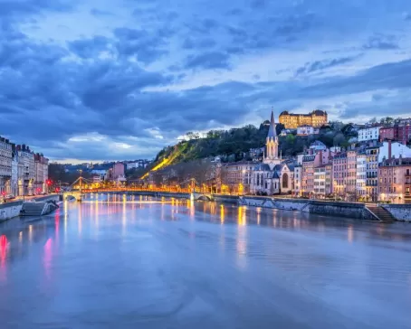 Warm lights glow through the blue hour in Lyon