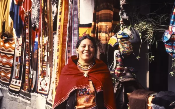 An Indigenous woman shows off her weavings