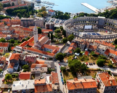 Admire the distinctive red roofs and Roman ruins of Pula