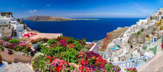 Colorful flowers and brilliant blue skies complement beautiful Greek islands