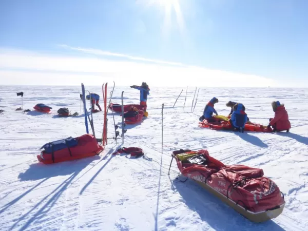 Skiers setting up camp on a sunny day. Courtesy Rob Smith, Antarctic Logistics & Expeditions
