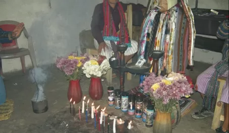 Maximon has candles, flowers, food, and incense