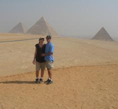 A couple poses in front of the pyramids.