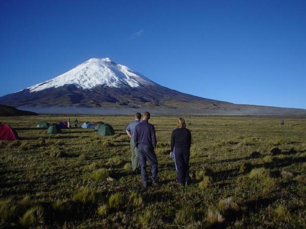 Trekkers take a moments to take in the view in the shadow of Ecuador's Cotopaxi Volcano