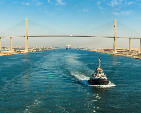 Ship passing through Suez Canal, in the background - the Suez Canal Bridge, also known as Al Salam Bridge