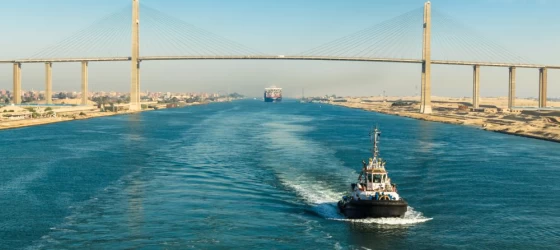 Ship passing through Suez Canal, in the background - the Suez Canal Bridge, also known as Al Salam Bridge