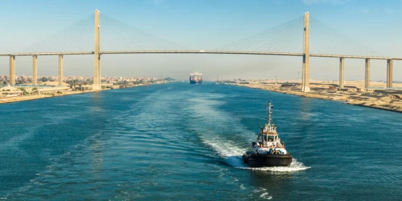 Ship passing through Suez Canal, in the background - the Suez Canal Bridge, also known as Al Salam Bridge