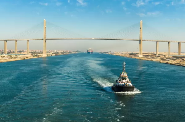 Ship passing through Suez Canal, in the background - the Suez Canal Bridge, also known as Al Salam Bridge