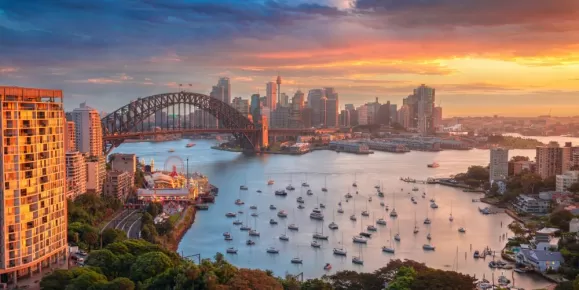 Cityscape image of Sydney, Australia with Harbour Bridge and Sydney skyline during sunset