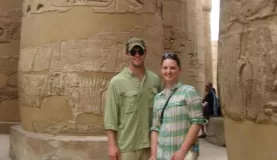 A couple standing amongst egyptian ruins.
