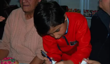 A young boy learning the ancient craft of masapan figurines.