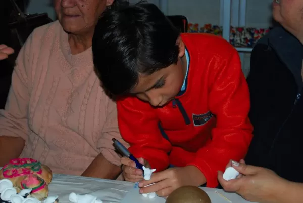 A young boy learning the ancient craft of masapan figurines.