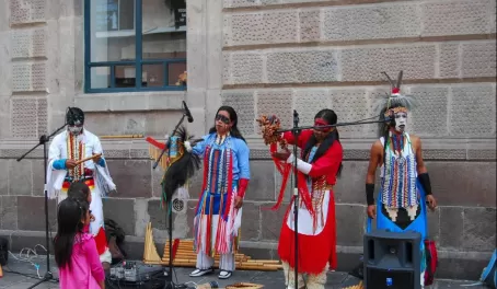 Native Ecuadorians in costumes with instruments