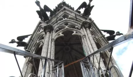 a dizzying climb to the top on metal stairs with gargoyles  