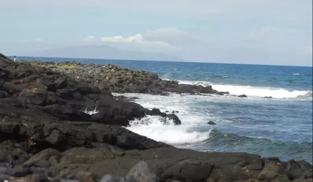 The volcanic rocks rolling in to the surf