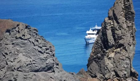 Odyssey yacht with the Pinnacle Rock, Bartolome Island