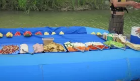 Guides serving lunch on an overturned raft, Pacuare River