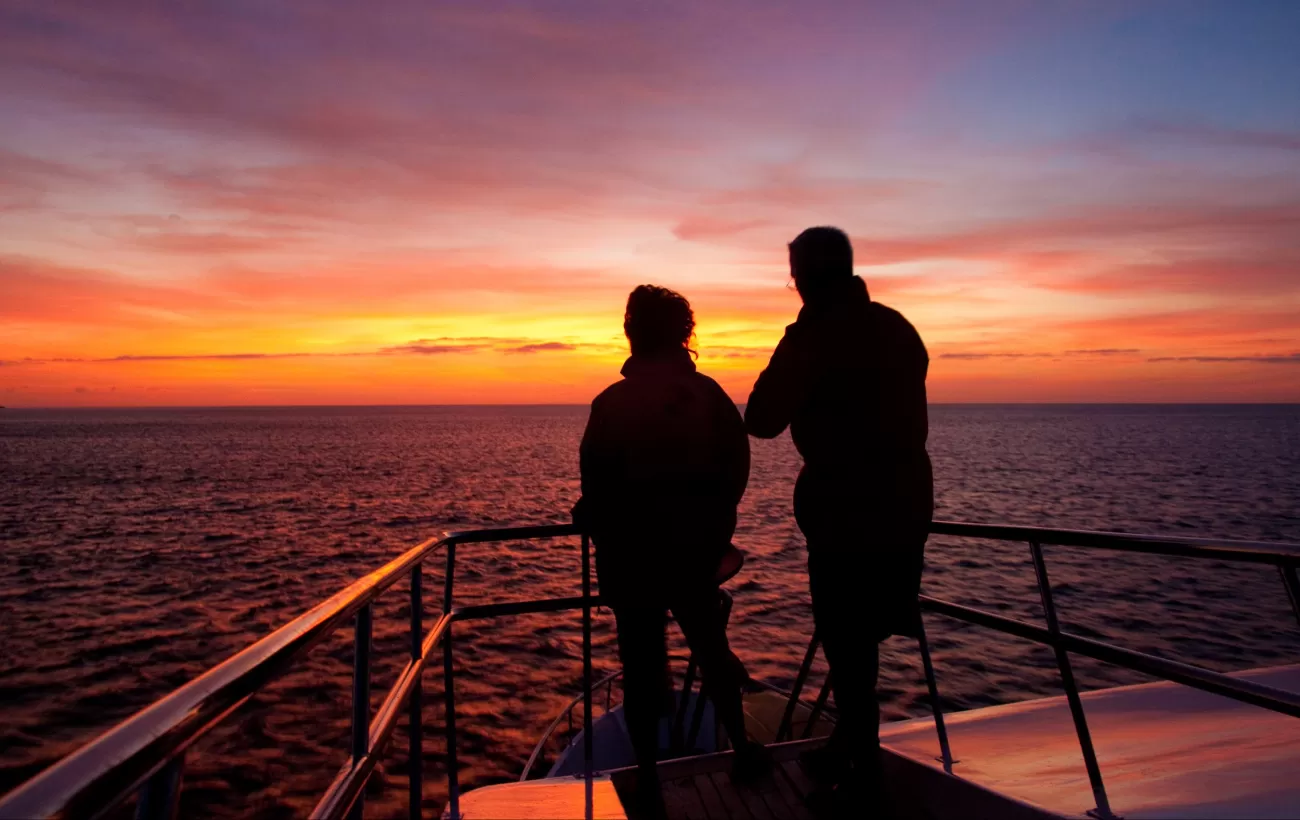 Watch the sun set over the warm Galapagos waters after a day of adventure