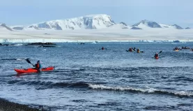 The Kayakers in the Weddell Sea approach the shore after spying out icebergs.