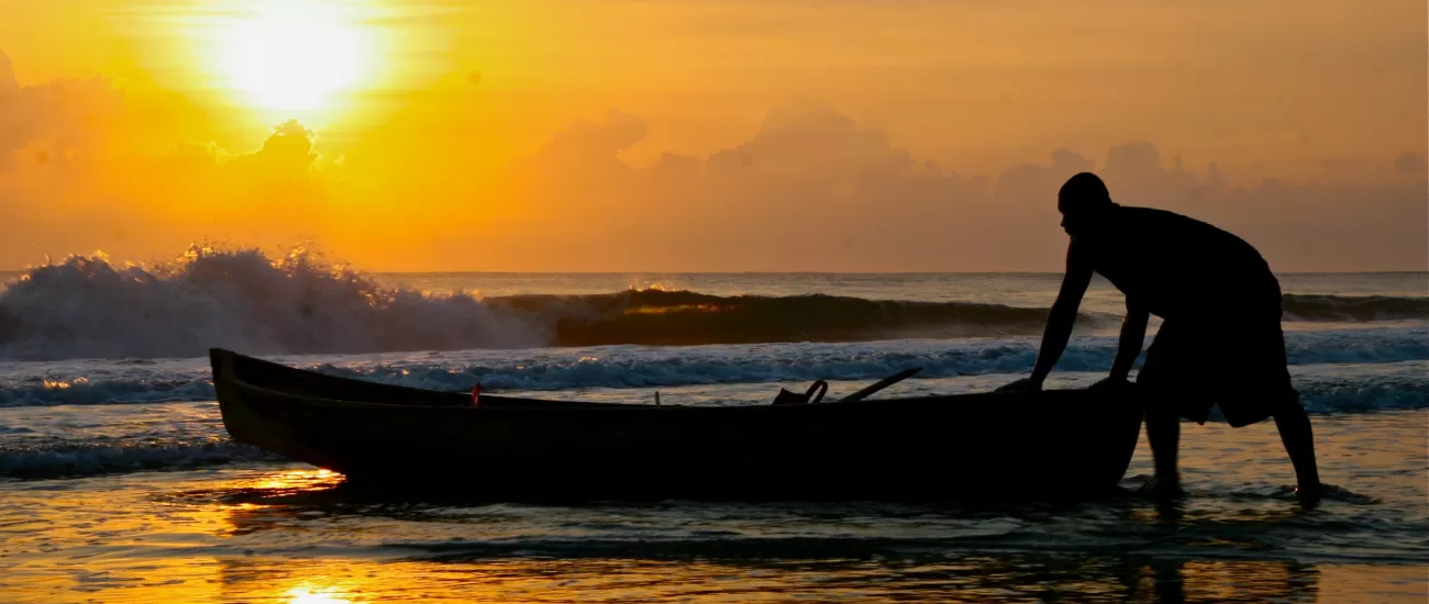 A local fisherman pulls his boat ashore at sunset in Costa Rica