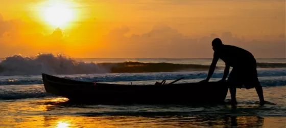 A local fisherman pulls his boat ashore at sunset in Costa Rica