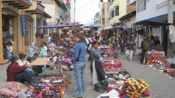 A traveler haggles with an artisan worker at the Otavalo Market