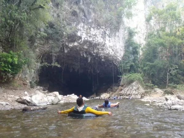 A guided tubing trip enters the mouth of the cave