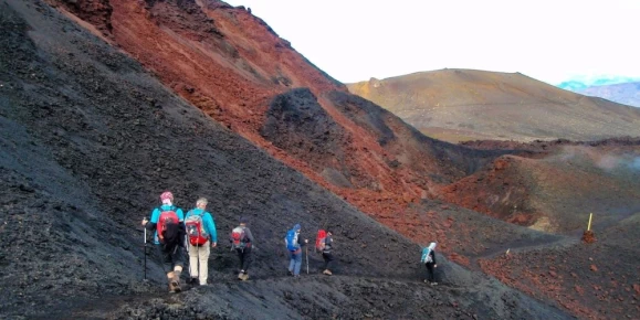A group with a guide hiking on a sandy mountain on Fimmvorduhals