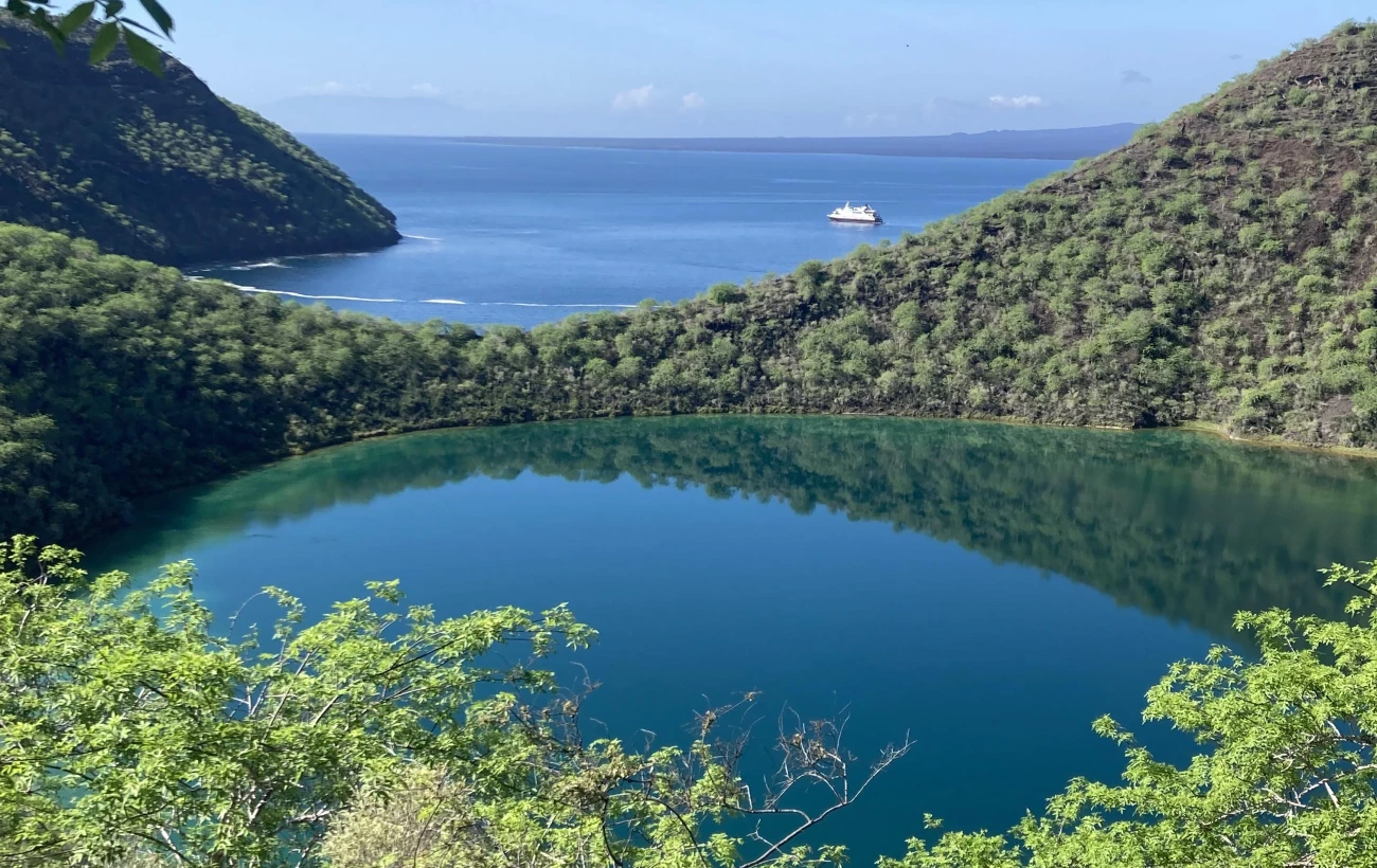 Vantage point of the saltwater volcanic crater lagoon, Darwin Lake and the Santa Cruz II anchored in the distance on the volcanic caldera, Tagus Cove.
