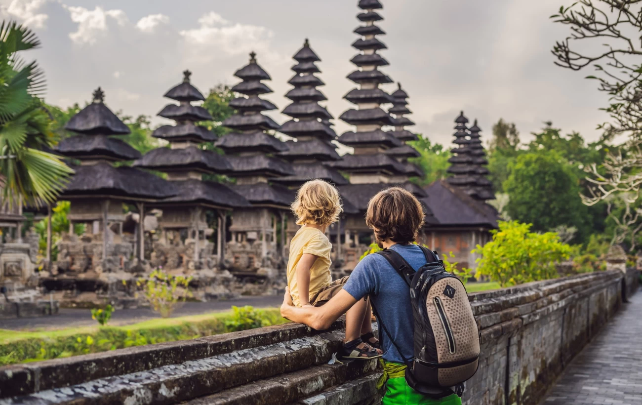 Father and son tour a traditional Balinese Hindu temple in Bali, Indonesia.