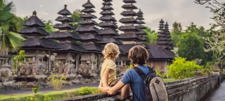 Father and son tour a traditional Balinese Hindu temple in Bali, Indonesia.