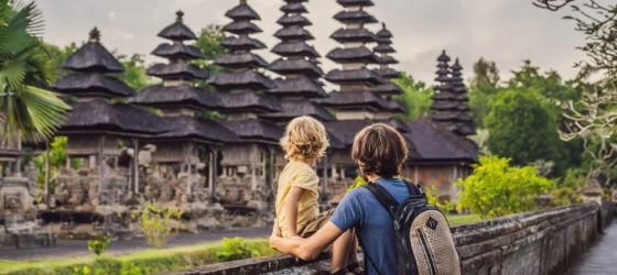 Father and son tour a traditional Balinese Hindu temple in Bali, Indonesia.