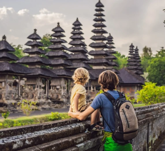 Father and son tour a traditional Balinese Hindu temple in Bali, Indonesia.