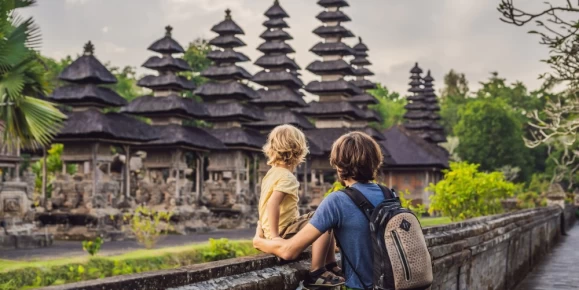 Father and son tour a traditional Balinese Hindu temple in Bali, Indonesia.