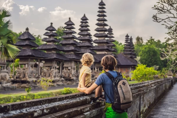 Father and son tour a traditional Balinese Hindu temple in Bali, Indonesia.
