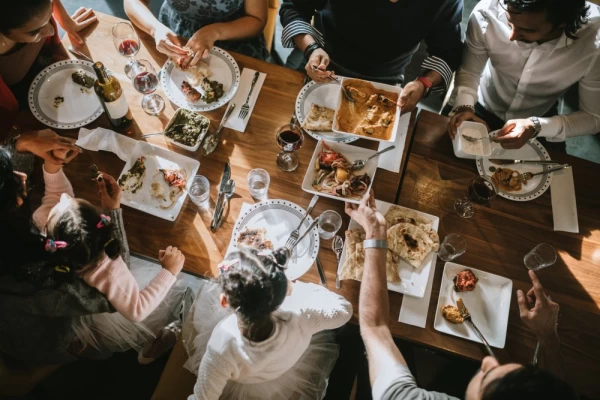 A warm gathering of Indian friends and family enjoys a feast of delicious traditional dishes.